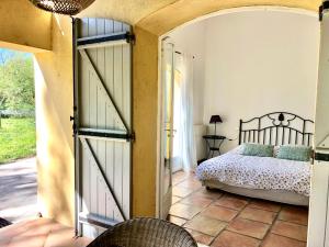 Schlafzimmer mit einer Tür, die zu einem Bett führt in der Unterkunft Terre de Sel in Grimaud + 41 Fotos