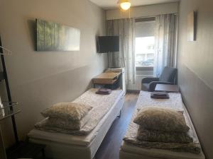 a small room with two beds and a chair at Matkakoti Patria Hostel - single & double rooms in Lahti