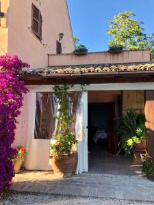 una entrada a un edificio con macetas y flores en Appartamento fronte piscina en Montemarciano