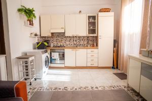 uma cozinha com armários brancos e uma máquina de lavar louça em Ciuri Ciuri em Isola delle Femmine
