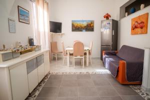 uma cozinha e uma sala de estar com uma mesa e um sofá em Ciuri Ciuri em Isola delle Femmine