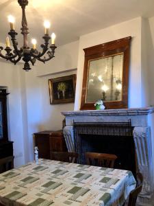 a dining room with a table and a fireplace at Appartamento fronte piscina in Montemarciano