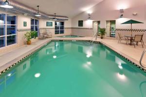 einen großen Pool mit einem Tisch und Stühlen in der Unterkunft Country Inn & Suites by Radisson, Lake George Queensbury, NY in Lake George
