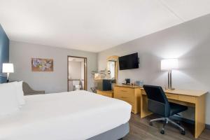 Habitación de hotel con cama, escritorio y ordenador en Econo Lodge en Branson
