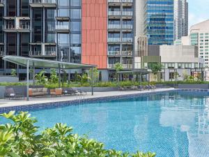 duży basen przed niektórymi budynkami w obiekcie Mercure ICON Singapore City Centre w Singapurze
