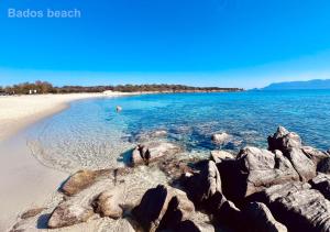 a view of a beach with rocks in the water at Sole Matto Rooms in Olbia