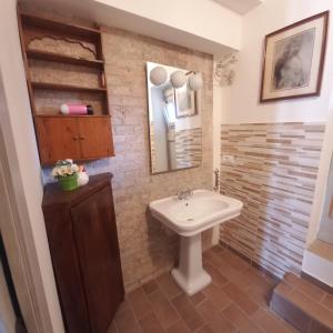 a bathroom with a sink and a mirror at Appartamento fronte piscina in Montemarciano