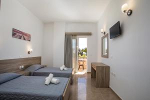 a hotel room with two beds and a television at Al Mare Apartments in Afantou