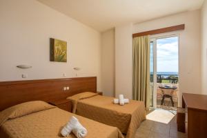 a hotel room with two beds and a balcony at Al Mare Apartments in Afantou