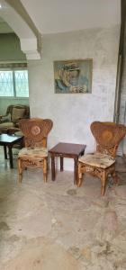 Zimmer mit Stühlen, einem Tisch und einer Bank in der Unterkunft Um Al namel in Irbid