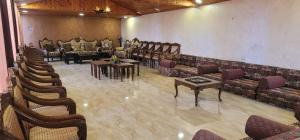 Großes Zimmer mit Sofas, Tischen und Stühlen in der Unterkunft Um Al namel in Irbid