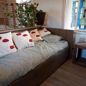 una cama con almohadas en una habitación en Erve Boonk, en Neede