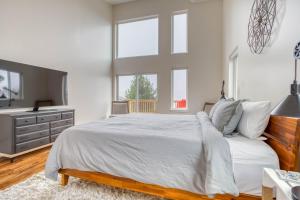 a bedroom with a white bed with a dresser and windows at Casabonita (MCA #50604) in Manzanita