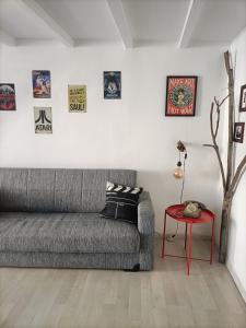uma sala de estar com um sofá cinzento e uma mesa vermelha em Maison 61 em Catânia