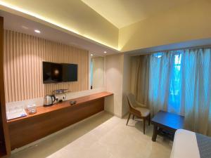 a hotel room with a desk and a television at Hotel Czar Inn - Vashi Navi Mumbai in Navi Mumbai