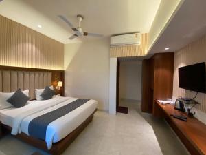 Habitación de hotel con cama y TV de pantalla plana. en Hotel Czar Inn - Vashi Navi Mumbai en Navi Mumbai