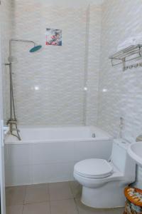 uma casa de banho com uma banheira branca, um WC e um lavatório. em Khách sạn Phú Yên em Liên Trì (3)