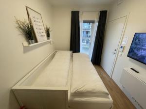 ein weißes Bett in einem Zimmer mit Fenster in der Unterkunft Clean and Modern - 25 Min to Oslo City & OSL in Lillestrøm + 40 Fotos