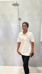 a woman standing in front of a shower at PM Lodge and Restaurant in Matemwe