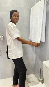 a woman standing in a bathroom holding a towel at PM Lodge and Restaurant in Matemwe