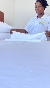 a woman sitting on a bed with towels at PM Lodge and Restaurant in Matemwe