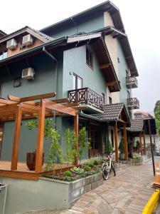 um edifício azul com uma varanda e uma moto estacionada no exterior em Pousada Belluno em Gramado