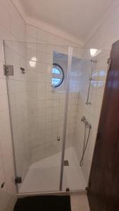 a shower with a glass door in a bathroom at Refugio dos Lima in Ericeira