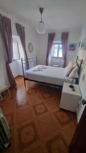 a bedroom with a bed and a lamp on a table at Refugio dos Lima in Ericeira