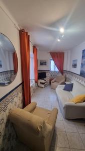 a living room with two couches and a mirror at Refugio dos Lima in Ericeira