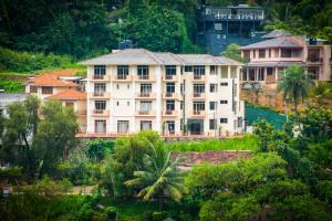 a large building on a hill with trees at Hotel Lakefield in Kandy