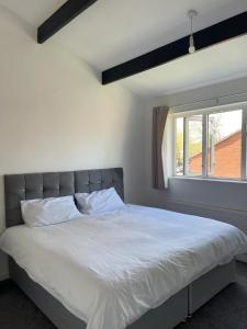 een slaapkamer met een groot wit bed en een raam bij Homestays-Close to Coventry City and University I Free Parking I Wi-Fi in Coventry