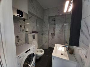 a bathroom with a washing machine and a sink at Bella Luxury Suite III in Paralia Katerinis