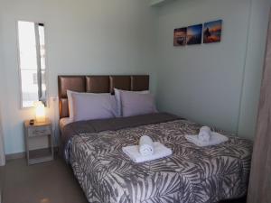 a bedroom with a bed with two towels on it at Bella Luxury Suite III in Paralia Katerinis
