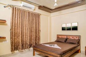 um quarto com uma cama e uma janela em Seasons The Resort em Alibag