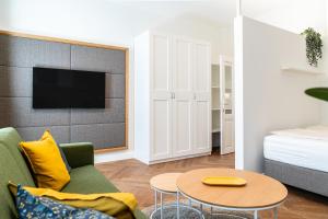 a living room with a green couch and a table at twenty five - work & life Apartments in Amstetten