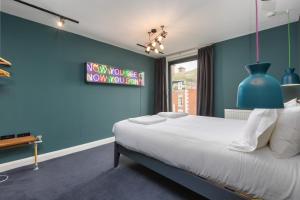 Dormitorio azul con cama y pared azul en ART B&B, en Blackpool