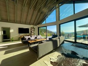 ein Wohnzimmer mit Sofas, Fernseher und Fenstern in der Unterkunft KissHaz in Sovata