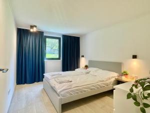 a bedroom with a large bed with blue curtains at KissHaz in Sovata