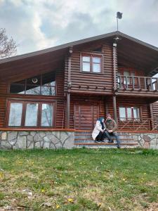 duas pessoas sentadas nos degraus de uma casa de madeira em Chalet's lake_Bolu Abant _log house em Piroğlu