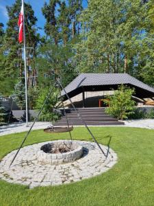 a fire pit in a park with a flag at Wczasy nad Odrą-Darmowe Jacuzzi in Gozdowice