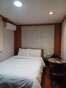 a bedroom with a bed and a desk with a phone at Gooreumseong motel in Seoul