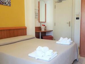 una camera d'albergo con due asciugamani su un letto di hotel bengasi a Rimini
