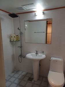a bathroom with a sink and a toilet and a mirror at Gooreumseong motel in Seoul