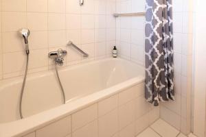 bagno con vasca e tenda doccia di LH Bremer Strasse, Hausteil 1 a Wenningstedt Altre 9 foto
