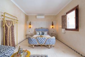 um quarto com uma cama azul e uma janela em Riad La Fayette Bed & Breakfast em Marrakech