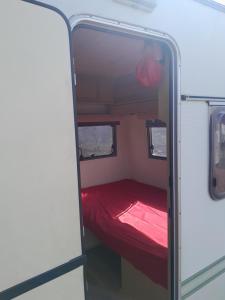 uma pequena cama na parte de trás de uma caravana em The Lakeside Cabin em Longmorn
