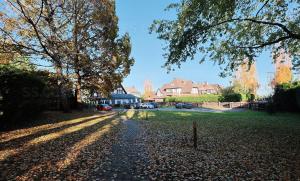 a cobblestone street in a residential neighborhood with trees and houses at Great Apartment next to the Lake Baltezers in Priedkalne