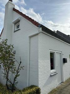 a white house with a window and a roof at Heerlijk Dijkhuisje in Paal in Graauw