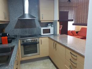 a kitchen with a stove and a microwave at Apartamento marítimo Benicarló 2 dormitorios con aparcamiento in Benicarló