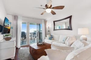 a living room with a couch and a ceiling fan at Baywatch C10 in Pensacola Beach